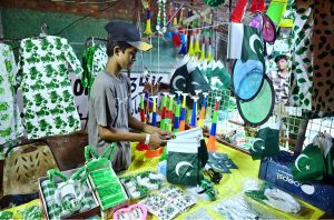 A vendor displays national flag-themed children’s outfits to attract customers as the nation prepares to celebrate Pakistan’s 79th Independence Day on August 14