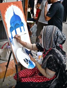 A student busy making a painting at stall near Peshawar Morr in the Federal Capital