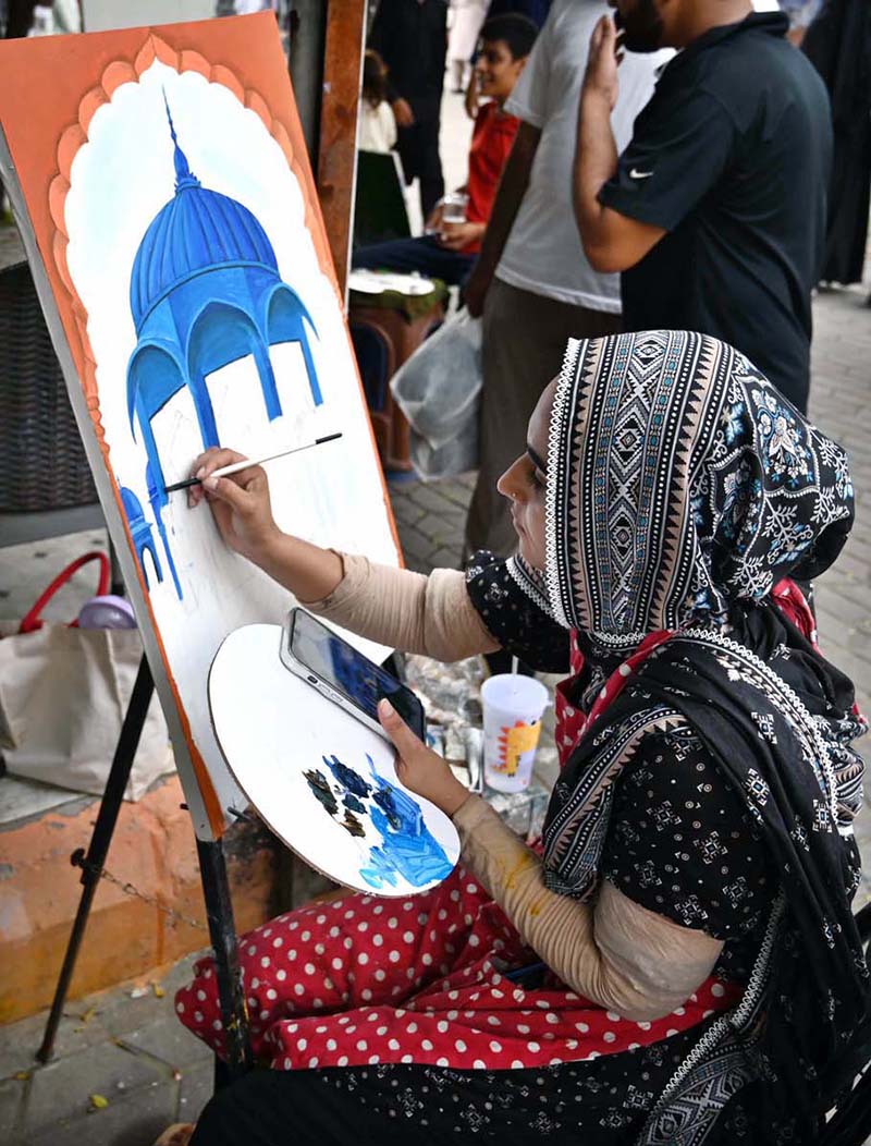 A student busy making a painting at stall near Peshawar Morr in the Federal Capital