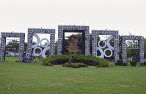 A gardener mows the lawn along the green belt on Faisal Avenue, featuring a portrait of Quaid-e-Azam Muhammad Ali Jinnah in the Federal Capital