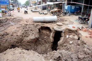 A dug-up section of road with an exposed manhole and sewer pipes during ongoing sewerage and drainage rehabilitation work is causing inconvenience to commuters and disrupting traffic flow in the city.
