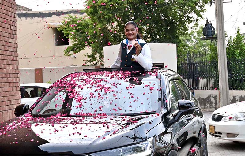 National boxer Fatima Zara proudly displays her Commonwealth Games bronze medal upon arrival at the Sports Gymnasium, where the District Sports Department hosted a reception in her honour and welcomed her with flower petals