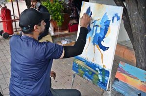 A student busy making a painting at stall near Peshawar Morr in the Federal Capital