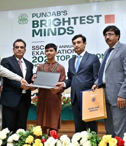 Commissioner Sargodha Hafiz Shaukat Ali and Chairman Board of Intermediate and Secondary Education (BISE) Sargodha Abbas Haider Gondal present an award to the first position holder in the Matriculation Examination 2026 during a prize distribution ceremony at the BISE Multipurpose Hall.