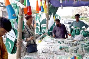People purchase national flags, badges, pennants and other patriotic items as the nation prepares to celebrate Independence Day with traditional zeal and enthusiasm