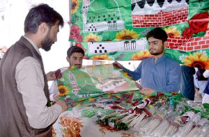 A man purchases flags from a vendor along Prince Road ahead of Eid Milad-un-Nabi celebrations.