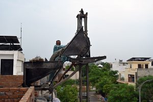 Construction workers build a reinforced concrete water tank on the rooftop of an under-construction building in the Federal Capital