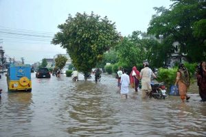 A veiled woman crosses a waterlogged road after heavy monsoon rain, as poor drainage caused flooding in parts of the city.