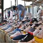 A vendor displaying used shoes to attract customers at weekly bazaar PWD in the Federal Capital