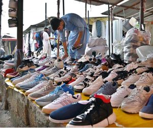 A vendor displaying used shoes to attract customers at weekly bazaar PWD in the Federal Capital