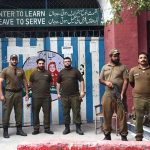 Police personnel are on duty outside a polling station in Garhi Shahu during the second phase of Azad Kashmir elections