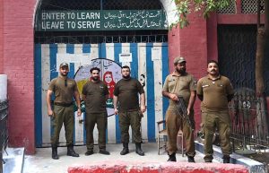 Police personnel are on duty outside a polling station in Garhi Shahu during the second phase of Azad Kashmir elections
