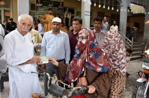 Federal Minister for board of investment, Qaiser Ahmad Shaikh distributing 5 litre free petrol slips to the motor cycles and rickshaw in the celebration of Independence Day
