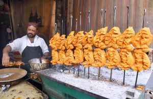 A vendor preparing traditional chicken roast for customers outside his restaurant at Railway Station Road.