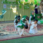 School students dressed in national colours perform during a ceremony held to celebrate Independence Day of Pakistan