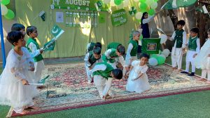 School students dressed in national colours perform during a ceremony held to celebrate Independence Day of Pakistan