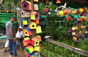 A vendor displays handmade wooden bird nests to attract the customers at outside their plants nursery.