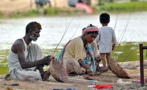 A couple weaves traditional handmade baskets from dried tree branches on the bank of the Nau Bahar Canal, preserving a centuries-old craft while earning a livelihood in the city.