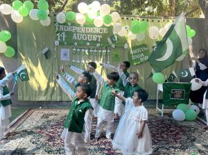 School students dressed in national colours perform during a ceremony held to celebrate Independence Day of Pakistan