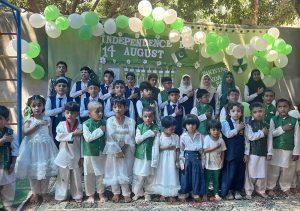 School students dressed in national colours perform during a ceremony held to celebrate Independence Day of Pakistan