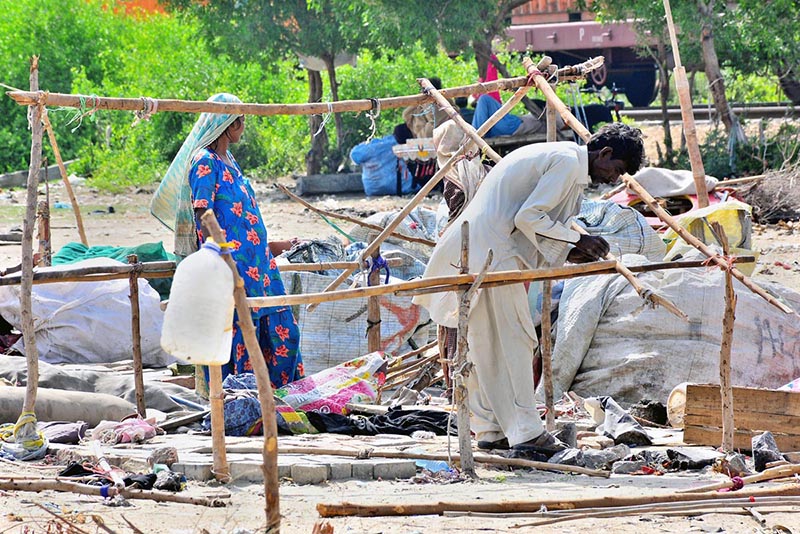 A gypsy family busy in preparing temporary hut for living outside road at Makki Shah Area