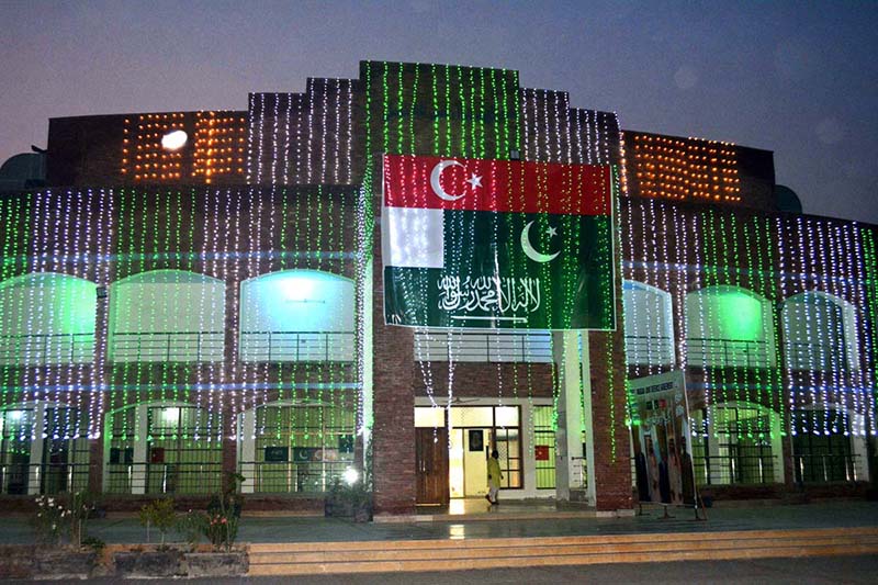 A view of the beautifully illuminated Sargodha Arts councial building with green lights and national flags on the eve of celebrations marking the Makkah Joint Defence Agreement signed by Pakistan, Saudi Arabia and Türkiye