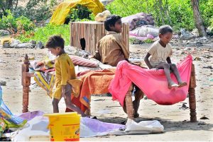 A gypsy family busy in preparing temporary hut for living outside road at Makki Shah Area