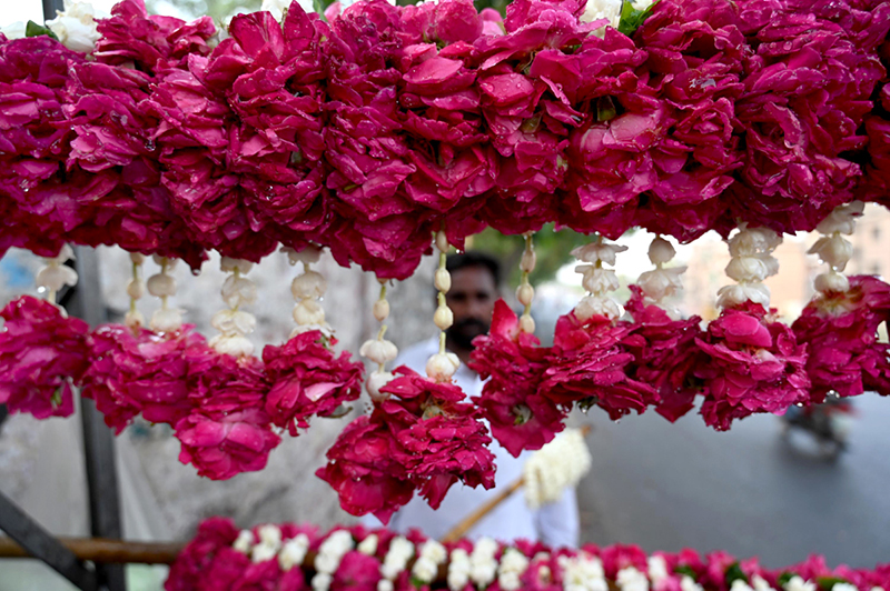 A vendor displaying the flowers garlands to attract the customers on the roadside footpath in the Provincial Capital