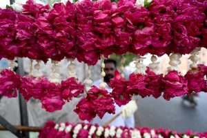 A vendor displaying the flowers garlands to attract the customers on the roadside footpath in the Provincial Capital