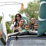 A family celebrates Independence Day on Mall Road in the city, expressing their patriotic spirit