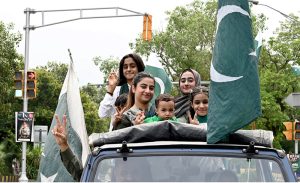 A family celebrates Independence Day on Mall Road in the city, expressing their patriotic spirit