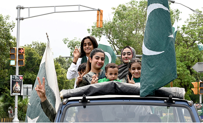 A family celebrates Independence Day on Mall Road in the city, expressing their patriotic spirit