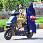 A girl rides an electric bike along Alamgir Road during routine traffic movement in the city
