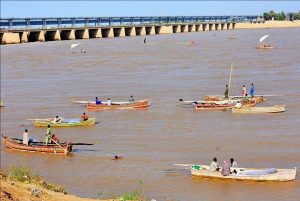 People spending time along the banks of the Indus River for recreation as water levels rise following heavy monsoon rains across the country