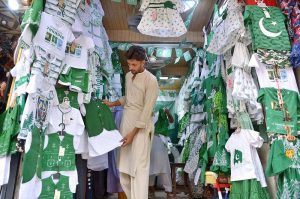 Vendors display National flags ,Pakistan-themed bands, toys and decorative items at a roadside stall ahead of Independence Day celebrations at Qissa Khawani Bazaar