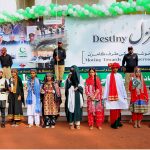 Children dressed in traditional attire and holding national flags participate in a ceremony to mark Pakistan’s 79th Independence Day in the city
