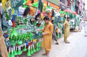 Vendors display National flags ,Pakistan-themed bands, toys and decorative items at a roadside stall ahead of Independence Day celebrations at Qissa Khawani Bazaar
