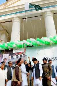 Children dressed in traditional attire and holding national flags participate in a ceremony to mark Pakistan’s 79th Independence Day in the city