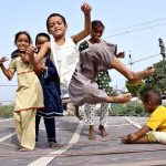 Children enjoy bouncing on a trampoline near the Railway Station