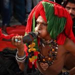 A devotee (malang) performing musical instrument Bigul at outside the Data Darbar while a large number of people arrives to attend the three day 983Urs celebration of renowned Sufi Data Gunj Buksh