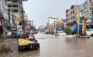 Train passes over a bridge as vehicles lie stranded in deep floodwater below, following heavy monsoon rain at Rahimabad area in the City.