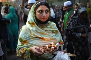 A devotee (malang) performing musical instrument Bigul at outside the Data Darbar while a large number of people arrives to attend the three day 983Urs celebration of renowned Sufi Data Gunj Buksh