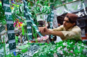 A vendor displays Pakistan Independence Day-themed children dresses, shirts at a roadside stall in Qissa Khawani Bazaar ahead of the country's 79th Independence Day celebrations.