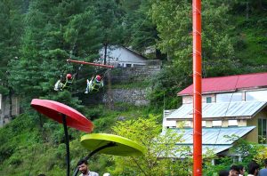 Tourists enjoy the scenic beauty of Miran Jani Water Fall, where cascading water flows through lush green surroundings, providing a refreshing retreat for visitors.