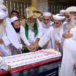 Pir Syed Sajad Shah Badshah and Pir Syed Enayat Shah along with others cutting a cake of Eid Milad-un-Nabi (SAWW)
