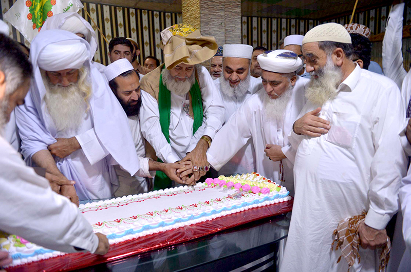 Pir Syed Sajad Shah Badshah and Pir Syed Enayat Shah along with others cutting a cake of Eid Milad-un-Nabi (SAWW)