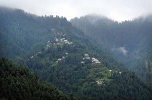 Tourists enjoy the scenic beauty of Miran Jani Water Fall, where cascading water flows through lush green surroundings, providing a refreshing retreat for visitors.