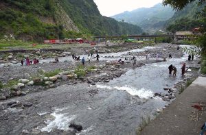 Tourists enjoy the scenic beauty of Miran Jani Water Fall, where cascading water flows through lush green surroundings, providing a refreshing retreat for visitors.