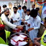 Volunteers serving traditional drinks to people during a rally to celebrate Eid Milad-un-Nabi