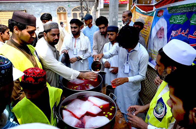 Volunteers serving traditional drinks to people during a rally to celebrate Eid Milad-un-Nabi